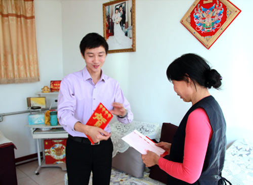 集团人力行政中心副总经理侯宝英（左）向员工家属发放慰问品